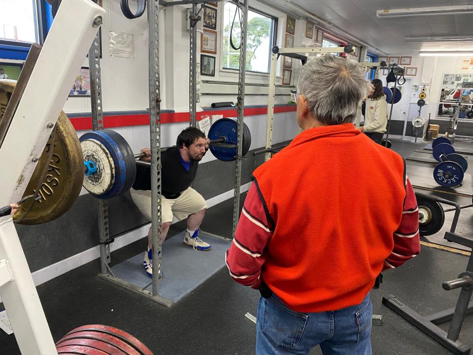 Ray Carr, 29, squats while Joe Orengia, 77, looks on during a training session at Joe’s Gym on West Ridge Road.