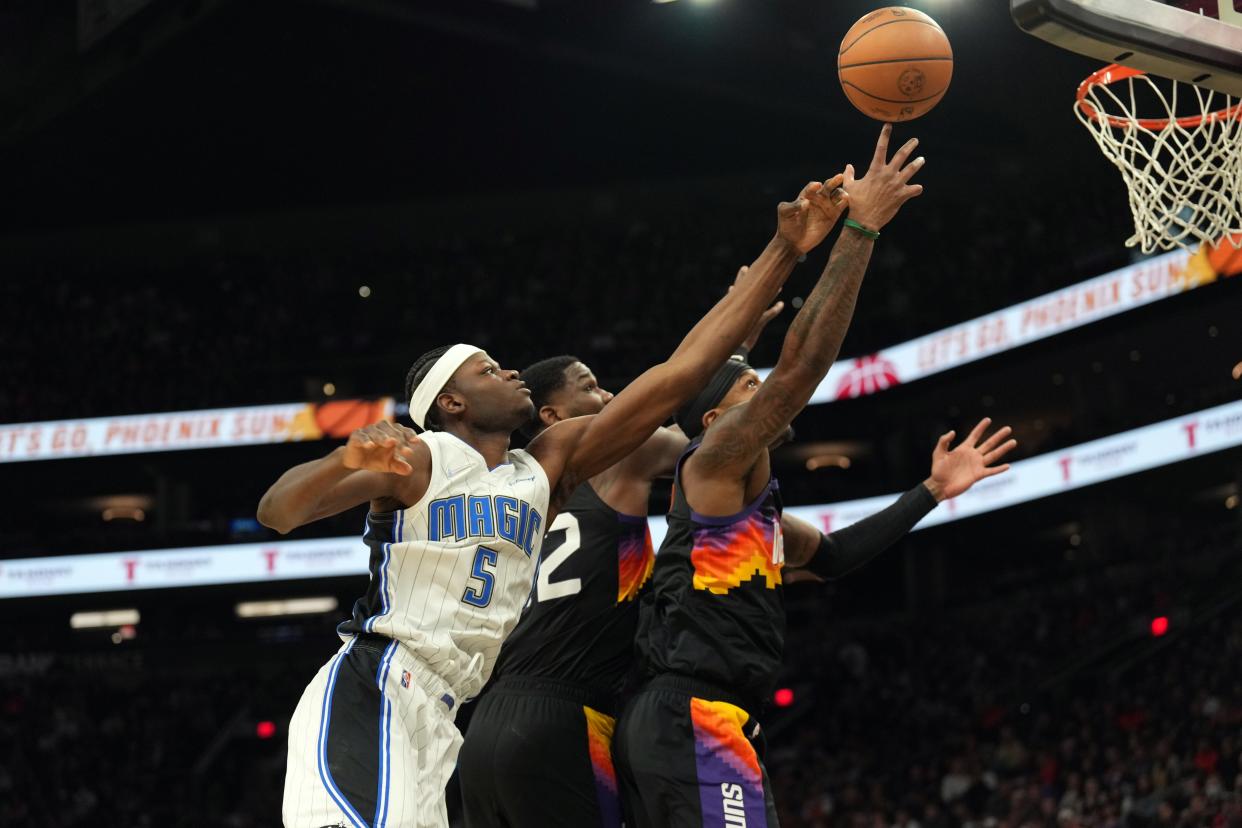 Feb 12, 2022; Phoenix, Arizona, USA; Orlando Magic center Mo Bamba (5) and Phoenix Suns center Deandre Ayton (22) and forward Torrey Craig (0) go after a rebound during the first half at Footprint Center. Mandatory Credit: Joe Camporeale-USA TODAY Sports