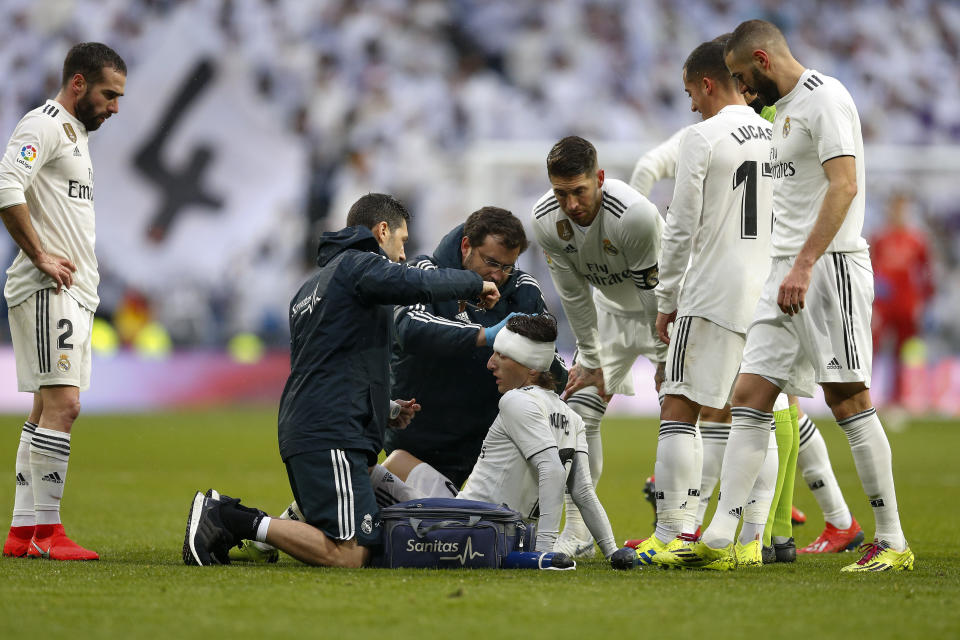 Real Madrid's Luka Modric, center, is attended by medical workers after being injured during La Liga soccer match between Real Madrid and Sevilla at the Bernabeu stadium in Madrid, Spain, Saturday, January 19, 2019. (AP Photo/Andrea Comas)