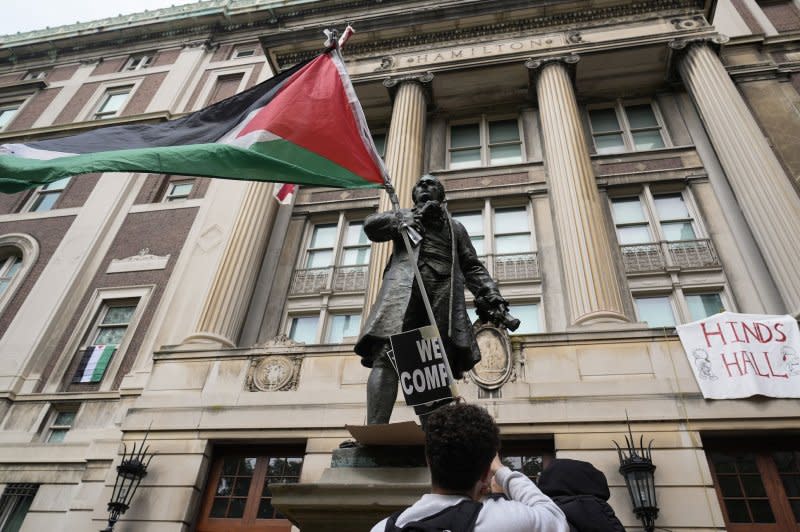 A Palestinian flag waves from a statue of Alexander Hamilton outside Hamilton Hall on Tuesday at Columbia University in New York City. Students protesting the war in Gaza barricaded themselves inside the building and said they would remain at the hall until the university concedes to their demands. Pool Photo by Michael M. Santiago/UPI