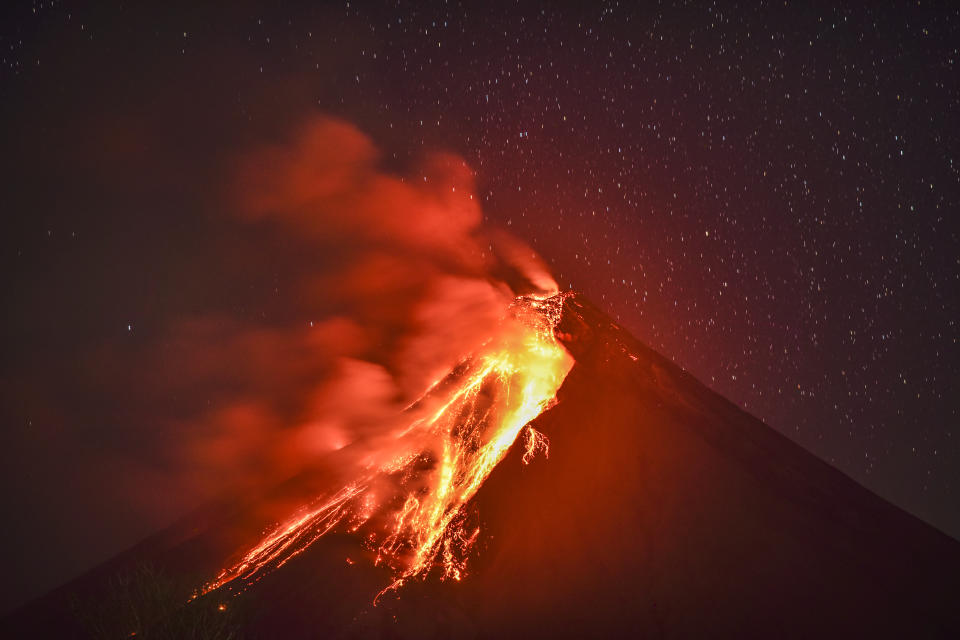 <p>Lava flows down the slope of Mount Mayon as seen from Legazpi, Albay province, Philippines, on the evening of Jan. 23, 2018. (Photo: Ezra Acayan/NurPhoto via Getty Images) </p>