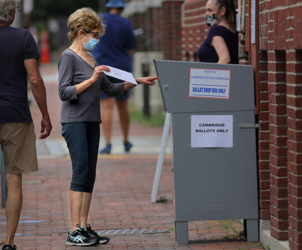 A voter drops off a mail-in ballot in a collection box in Cambridge, Mass. on Aug. 25.<span class="copyright">Lane Turner—The Boston Globe/Getty Images</span>