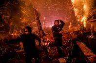 <p>John Bain and Brandon Baker take cover from the embers as they try to help stop a fire from burning a stranger’s home on December 5, 2017 in Ventura, Calif. (Photo: Marcus Yam/Los Angeles Times via Getty Images) </p>