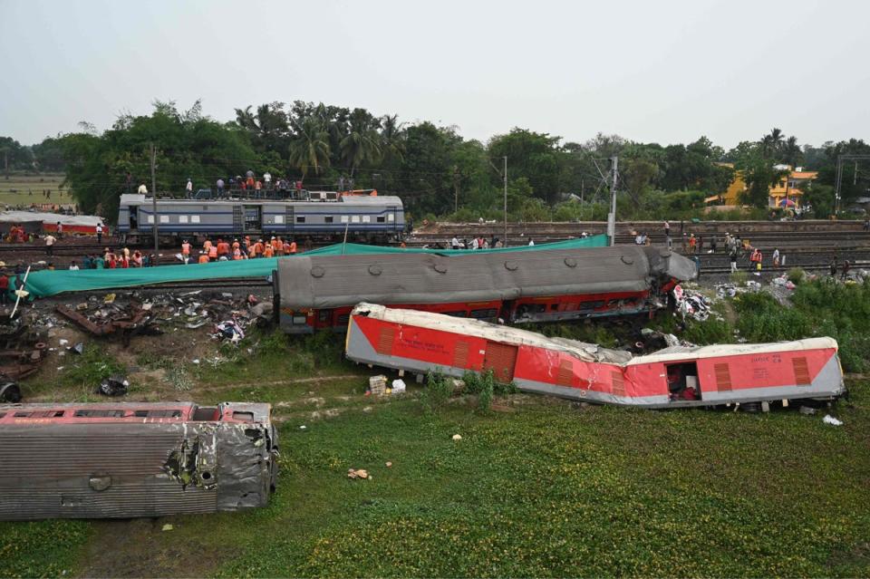 Railway workers help to restore services at the site of the three-train collision near Balasore, about 125 miles from Bhubaneswar in the eastern state of Odisha (AFP via Getty Images)