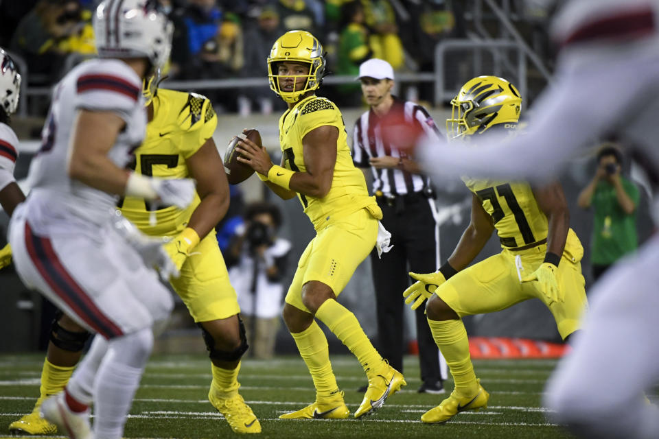 FILE - Oregon quarterback Ty Thompson, center, looks for a receiver during the fourth quarter of an NCAA college football game against Stony Brook, Saturday, Sept. 18, 2021, in Eugene, Ore. Oregon first-year coach Dan Lanning isn't dropping any clues about his starting quarterback this season. Fall camp has been a battle behind closed doors between transfer Bo Nix and redshirt freshmen Thompson and Jay Butterfield. (AP Photo/Andy Nelson, File)