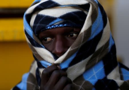 FILE PHOTO: A migrant waits for the MV Aquarius, a search and rescue ship run in partnership between SOS Mediterranee and Medecins Sans Frontieres, to enter Pozzallo on the island of Sicily, Italy, December 18, 2017. REUTERS/Darrin Zammit Lupi/File Photo/File Photo