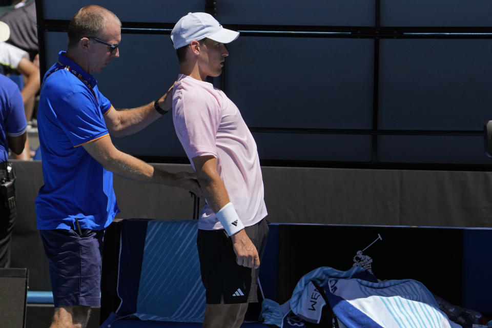 Dominic Thiem of Austria receives treatment from a trainer during his first round match against Andrey Rublev of Russia at the Australian Open tennis championship in Melbourne, Australia, Tuesday, Jan. 17, 2023. (AP Photo/Ng Han Guan)