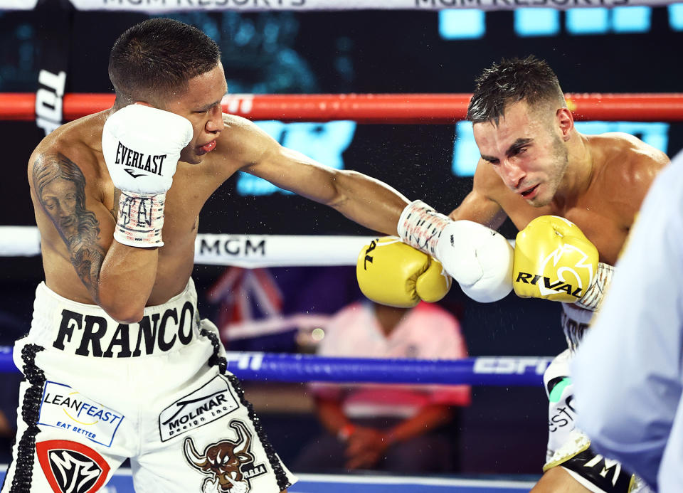 Joshua Franco (L) lands a left hands to Andrew Moloney en route to lifting the WBA super flyweight title via a unanimous decision Tuesday in Las Vegas. Judges scored it 114-113 twice and 115-112. (Mikey Williams/Top Rank)