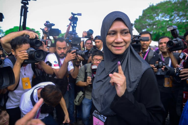 United Malays National Organisation (UMNO) candidate Mastura Mohamad Yazid shows her finger covered with indelible ink after casting her vote outside a polling station during a by-election in Kuala Kangsar on June 18, 2016