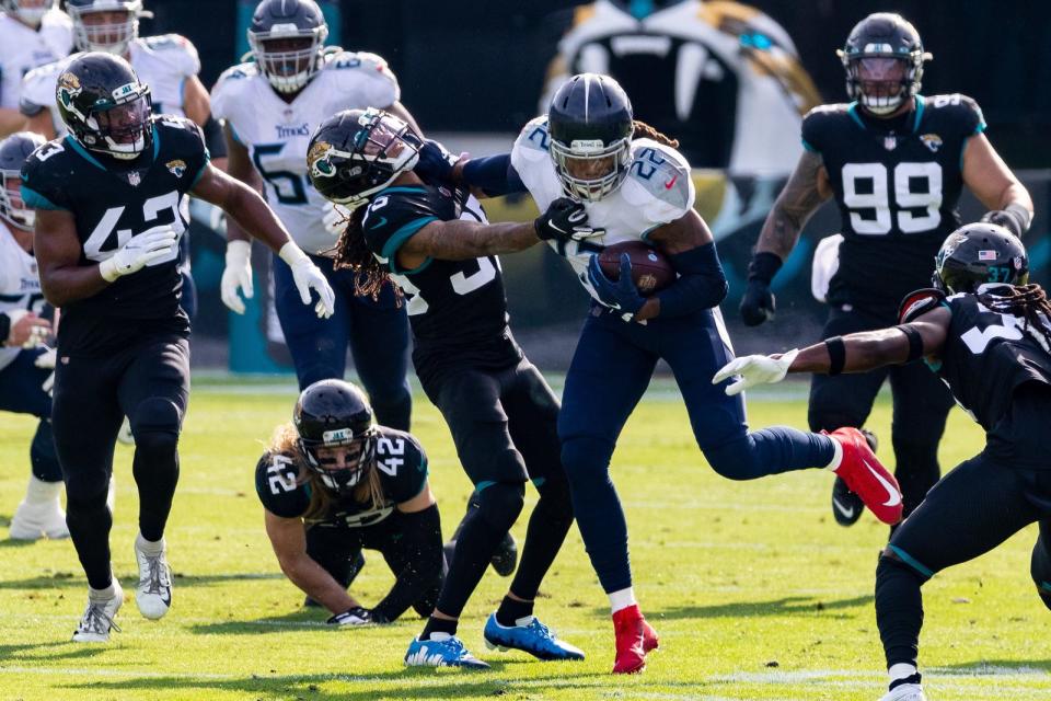 Tennessee Titans running back Derrick Henry (22) stiff arms Jacksonville Jaguars cornerback Sidney Jones (35) in the teams' December 2020 game.