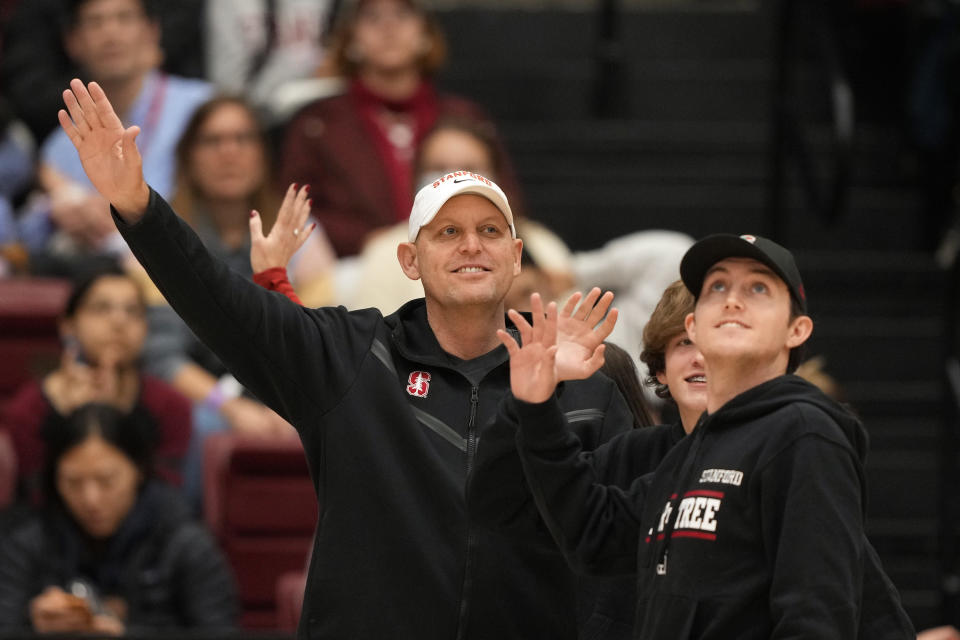 Dec 18, 2022; Stanford, California, USA; Stanford Cardinal football head coach Troy Taylor, center, waves while standing on the court with family during the second quarter of the game between the Stanford Cardinal and the Tennessee Lady Vols at Maples Pavilion. Mandatory Credit: Darren Yamashita-USA TODAY Sports