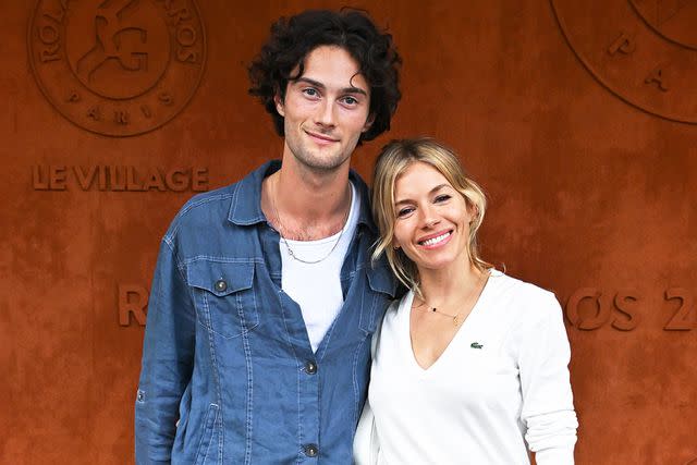 <p>Stephane Cardinale/Corbis/Getty</p> Oli Green and Sienna Miller on June 3, 2022