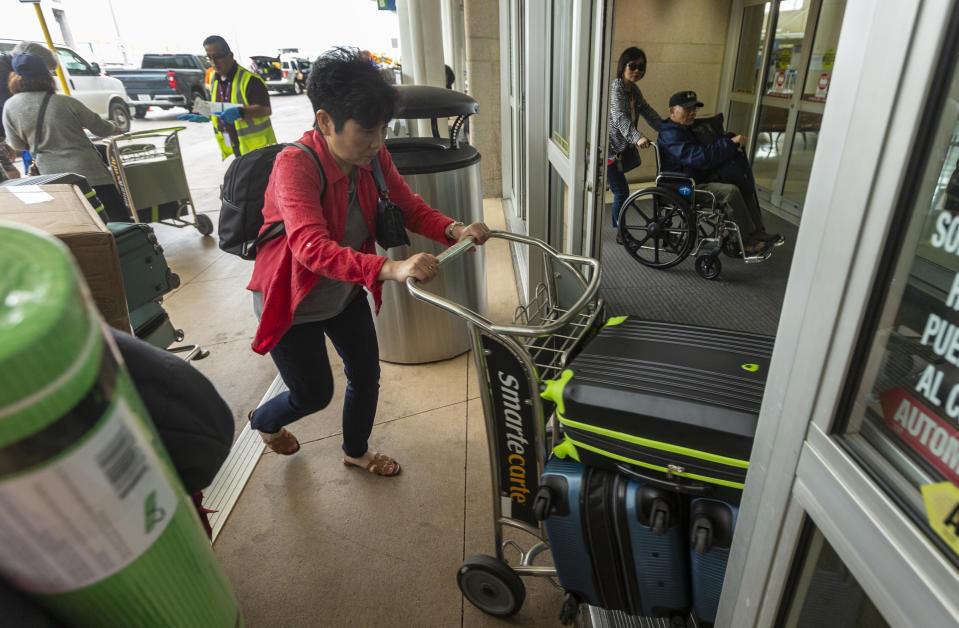 People arrive at the San Antonio International Airport Tuesday, March 3, 2020 after being released from quarantine at JBSA-Lackland. The people were evacuated from the coronavirus-infected Diamond Princess cruise ship in Japan and had been held in quarantine at Lackland to ensure they were not infected with the virus. (William Luther/The San Antonio Express-News via AP)