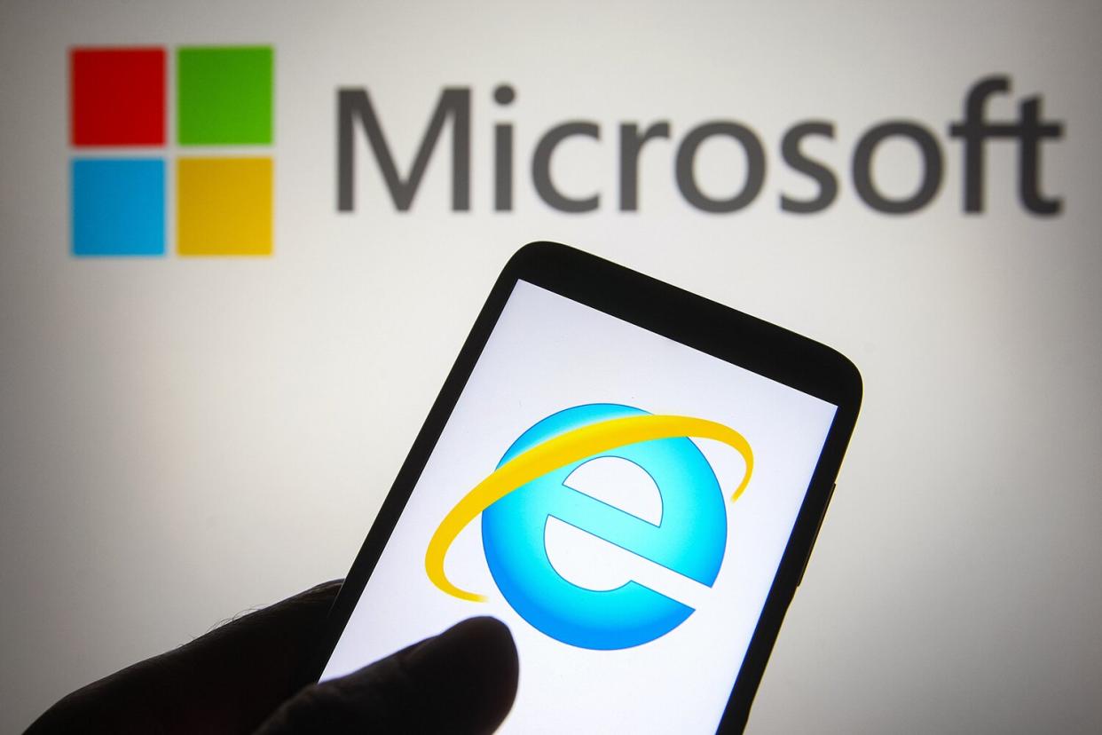 In this photo illustration an Internet Explorer (IE or MSIE) logo is seen on a smartphone with a Microsoft logo in the background.