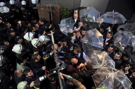 Employees block the door as riot police try to enter Kanalturk and Bugun TV building in Istanbul, Turkey, October 28, 2015. REUTERS/Usame Ari/Zaman Daily via Cihan News Ageny