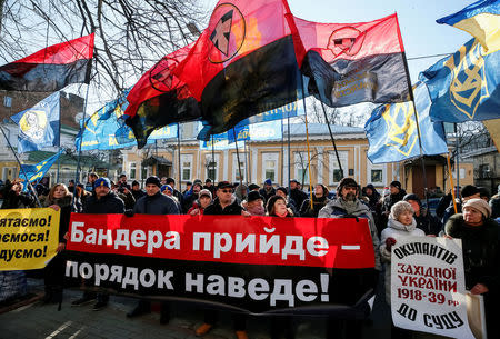 Activists and supporters of Ukraine's nationalist Svoboda (Freedom) party hold a banner that reads "Bandera will come and bring order", during a rally against a new Polish bill that would impose prison sentences of up to three years for mentioning the term "Polish death camps" and for suggesting complicity on the part of the Polish nation or state in Nazi Germany's crimes, outside the Polish embassy in Kiev, Ukraine February 5, 2018. REUTERS/Gleb Garanich