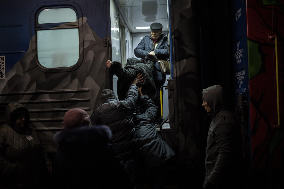 Ukrainians board the Kherson-Kyiv train at the Kherson railway station, southern Ukraine, Monday, Nov. 21, 2022. Ukrainian authorities are evacuating civilians from recently liberated sections of the Kherson and Mykolaiv regions, fearing that a lack of heat, power and water due to Russian shelling will make conditions too unlivable this winter. The move came as rolling blackouts on Monday plagued most of the country. (AP Photo/Bernat Armangue)