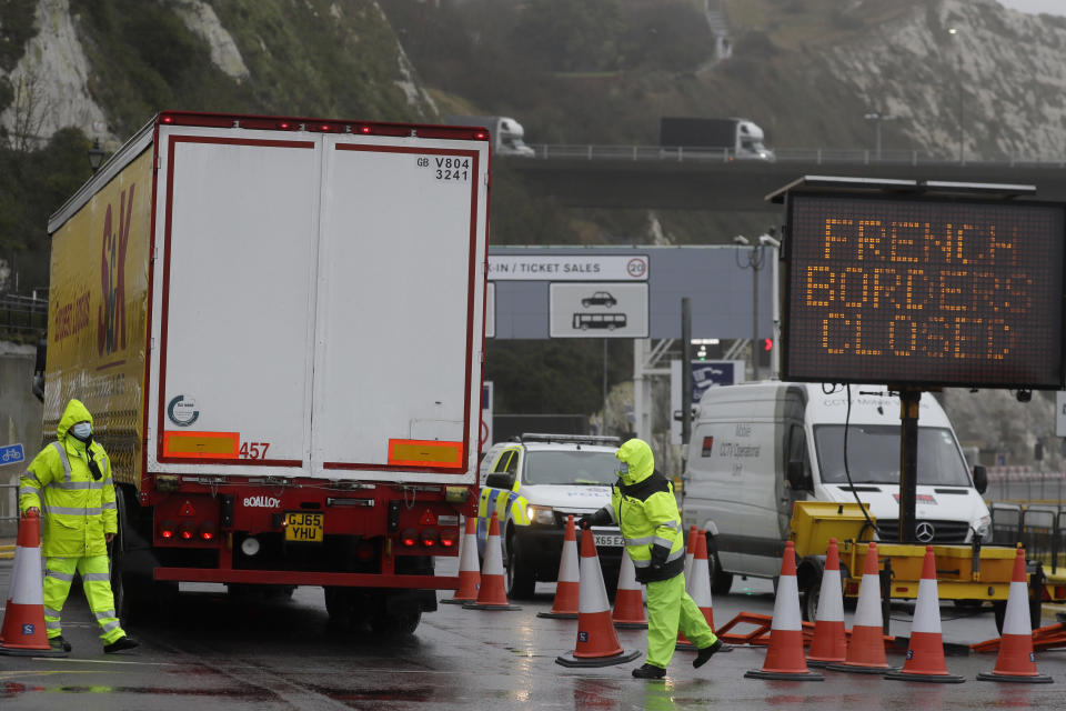 Security guard the entrance to the ferry terminal in Dover, England, Monday, Dec. 21, 2020, after the Port of Dover was closed and access to the Eurotunnel terminal suspended following the French government's announcement. France banned all travel from the UK for 48 hours from midnight Sunday, including trucks carrying freight through the tunnel under the English Channel or from the port of Dover on England's south coast. (AP Photo/Kirsty Wigglesworth)