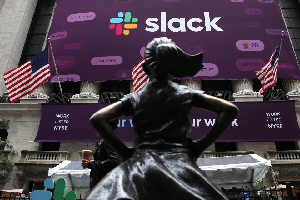 The Slack Technologies Inc. logo is seen behind the "Fearless Girl" statue outside the New York Stock Exchange (NYSE) during the company's IPO in New York, U.S. June 20, 2019.  REUTERS/Brendan McDermid