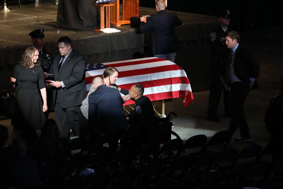 The funeral for Rochester Police Officer Anthony Mazurkiewicz was held in the Blue Cross Arena in Rochester, NY on Monday August 1, 2022,   A man, hiding in bushes on Bauman St. in Rochester,  fired numerous rounds from a gun at Mazurkiewicz and his partner, Officer Sino Seng, 37, on July 21, 2022.  Mazurkiewicz, 54,  was killed and Seng, was injured.  The funeral was only open to fellow officers and first responders.  After the funeral Lynn Mazurkiewicz gives her husband's partner, Seng, a hug.