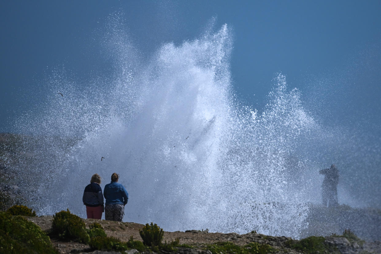 PORTLAND, ENGLAND - AUGUST 05: People watch as waves hit the coast at Portland Bill during Storm Antoni, on August 05, 2023 in Portland, England. (Photo by Finnbarr Webster/Getty Images)