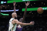 Boston Celtics guard Derrick White (9) passes the ball while pressured by Phoenix Suns center Bol Bol, right, during the first half of an NBA basketball game, Thursday, March 14, 2024, in Boston. (AP Photo/Charles Krupa)