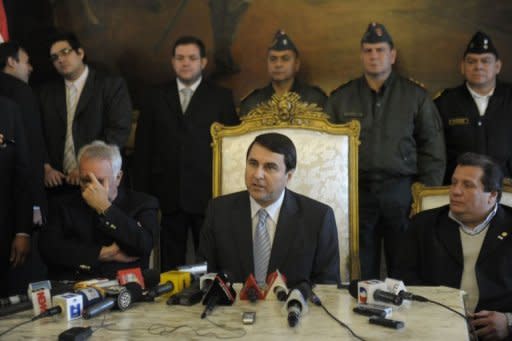 Paraguayan new President Federico Franco (C) speaks to the international press at the presidential palace after being sworn in as the country's new leader, in Asuncion. Franco pledged to demonstrate "a clear commitment to democracy" Saturday amid a mounting international outcry over his predecessor's sudden ouster by a vote of Congress