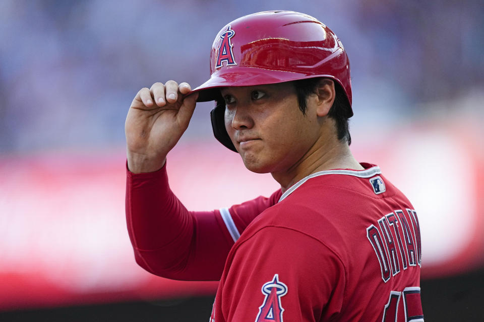 The Los Angeles Angels' Shohei Ohtani tips his helmet to a fan as he stands on third base in the first inning Monday against the Braves. (AP Photo/John Bazemore)