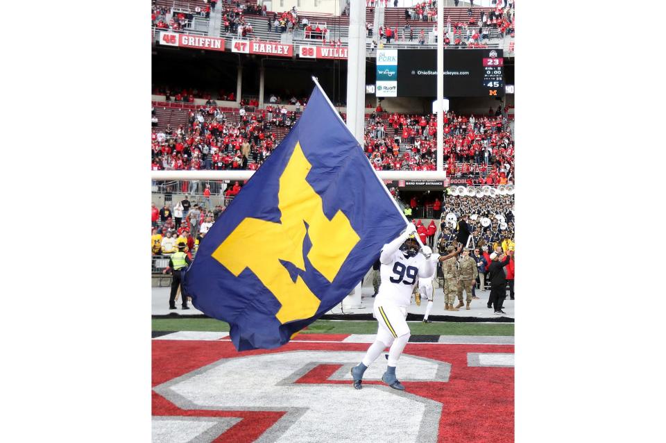 Michigan Wolverines defensive lineman Cam Goode (99) runs under the scoreboard with the 45-23 final score of their game against the Ohio State Buckeyes in Columbus on Saturday, Nov. 26, 2022.