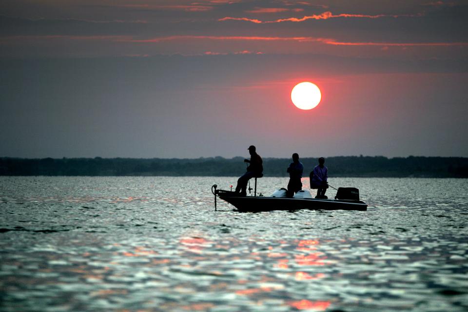 Anglers search for striped bass as the sun rises on Lake Texoma.