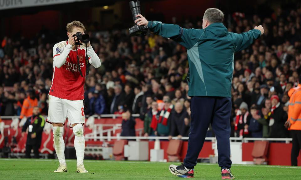 <span>Arsenal captain Martin Odegaard celebrates the win over by taking a picture of club photographer Stuart Macfarlane.</span><span>Photograph: Tom Jenkins/The Guardian</span>