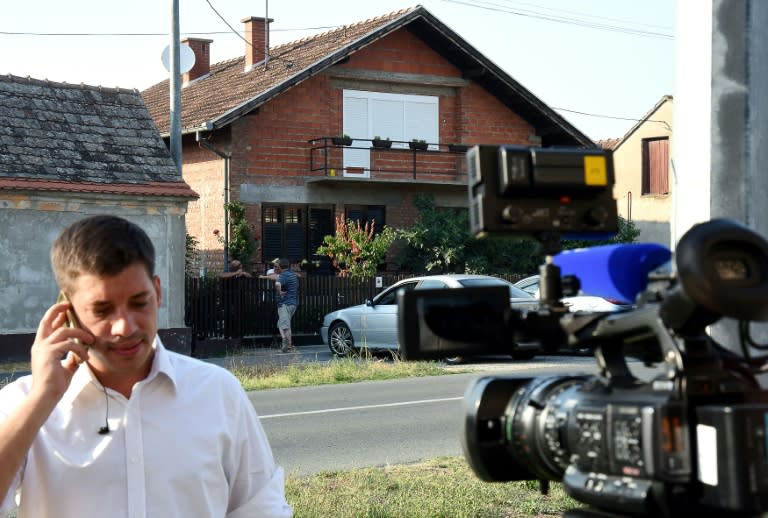A journalist speaks on the phone in front of the house of Croatian national Tomislav Salopek, who was abducted near Cairo by Islamic State group militants, in Vrpolje, Croatia, on August 7, 2015
