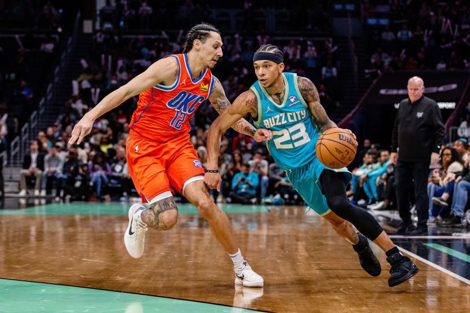 Apr 7, 2024; Charlotte, North Carolina, USA; Oklahoma City Thunder forward Lindy Waters III (12) defends the drive from Charlotte Hornets guard Tre Mann (23) during the fourth quarter at Spectrum Center. Mandatory Credit: Scott Kinser-USA TODAY Sports