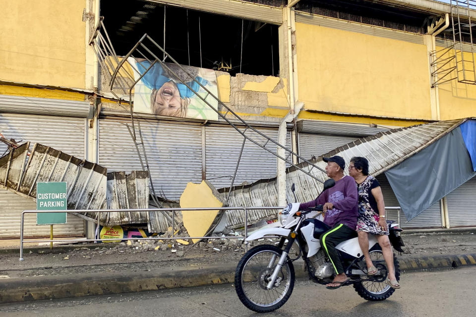 A motorcycle passes by a partially damaged grocery store caused by an earthquake in Bayugan City, Agusan del Sur, southern Philippines, Sunday morning, Dec. 3, 2023. A powerful earthquake with a preliminary magnitude of 7.6 struck Saturday, Dec. 2, off the southern Philippine coast, prompting many villagers to flee their homes in panic after Philippine authorities issued a tsunami warning. (AP Photo/Ivy Marie Mangadlao)