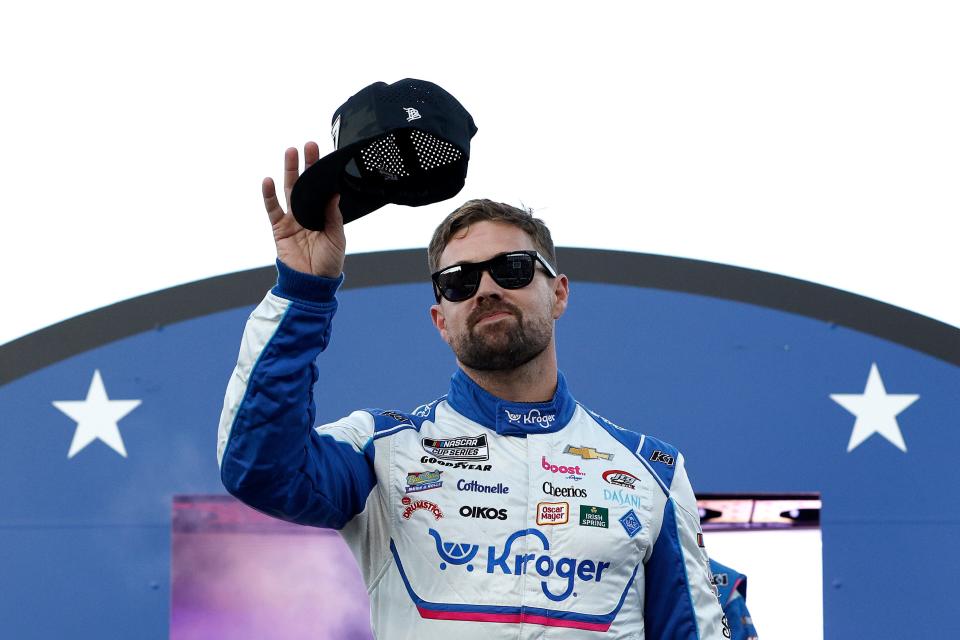 Ricky Stenhouse Jr. waves to fans as he walks onstage during driver introductions for the 2024 NASCAR All-Star Race at North Wilkesboro Speedway.