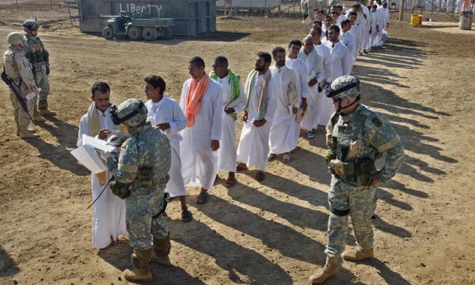 Detainees are checked by US soldiers during a prisoner release at Abu Ghraib prison on 01 October 2005.