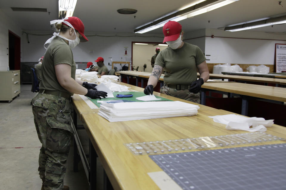 In this April 17, 2020 photo, U.S. Army soldiers work to assemble face masks in a rigger shed on Fort Bragg, N.C. N C State University donated the 4,000 meters being used to make the PPE being distributed to units across the base. (AP Photo/Sarah Blake Morgan)