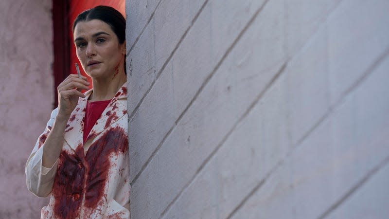 Rachel Weisz smokes a cigarette while dressed in a bloody lab coat on Dead Ringers.