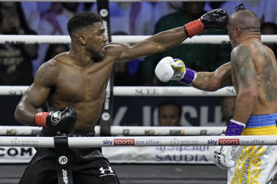 FILE - Britain's Anthony Joshua, right, lands a blow on Ukraine's Oleksandr Usyk during their world heavyweight title fight at King Abdullah Sports City in Jeddah, Saudi Arabia, Sunday, Aug. 21, 2022. Anthony Joshua and Deontay Wilder were once the main characters in heavyweight boxing’s soap opera but now they are extras. Wilder and Joshua are in the kingdom this weekend and fighting simply to stay relevant. (AP Photo/Hassan Ammar, File)