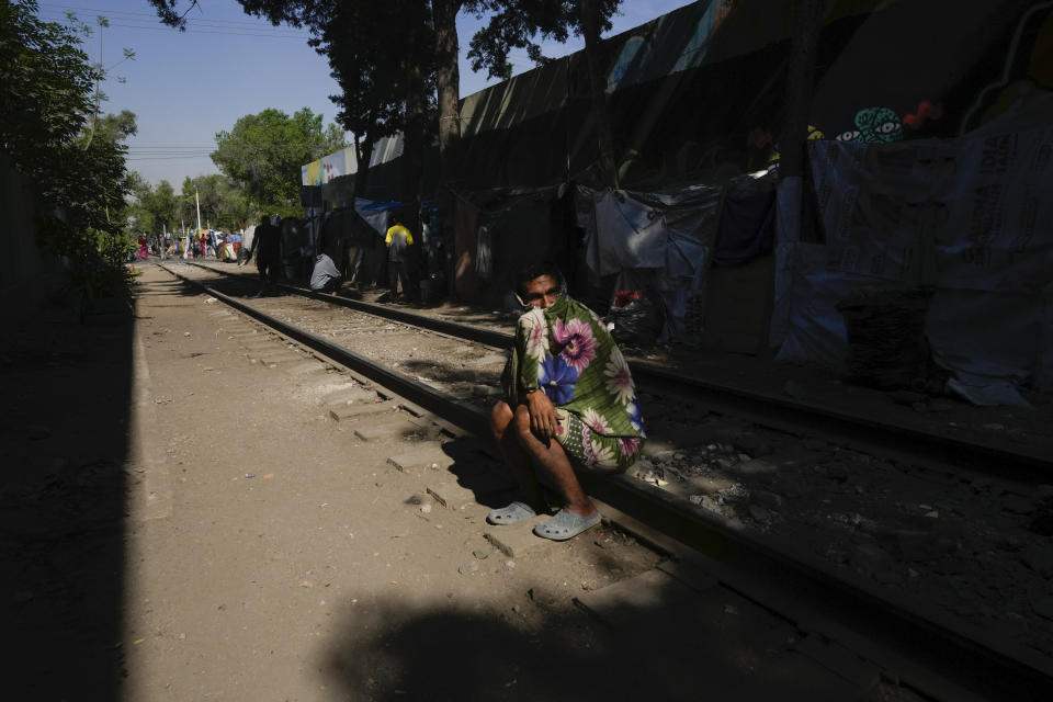 Un migrante de Maracaibo, Venezuela, sentado en una vía de ferrocarril bordeada de tiendas de campaña improvisadas donde los migrantes se refugian en la Ciudad de México, el martes 26 de marzo de 2024. (AP Foto/Fernando Llano)