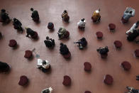 People wearing protective masks to help curb the spread of the coronavirus keep social distances as they sit in a public area Tuesday, Jan. 26, 2021 in Tokyo. The Japanese capital confirmed more than 1000 new coronavirus cases on Tuesday. (AP Photo/Eugene Hoshiko)