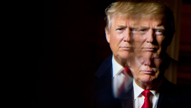 Then-Republican presidential candidate Donald Trump, seen in reflection, poses for a portrait following an interview with The Associated Press at the Trump National Golf Club in Sterling, Va., Wednesday, Dec. 2, 2015.