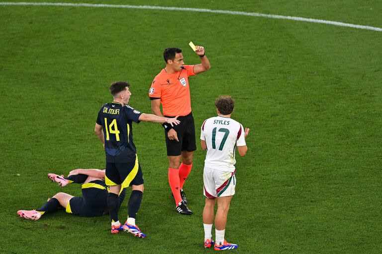 Facundo Tello le muestra la tarjeta amarilla al húngaro Callum Styles por una falta sobre el escocés Billy Gilmour