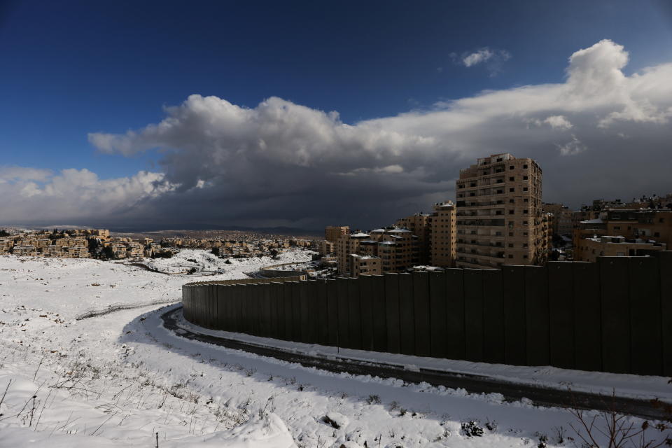 <p>Covered in snow, the Israeli barrier runs between Pisgat Zeev and the Shuafat refugee camp in East Jerusalem, in an area Israel annexed to Jerusalem after capturing it in the 1967 Middle East war, January 27, 2022. REUTERS/Ammar Awad</p>
