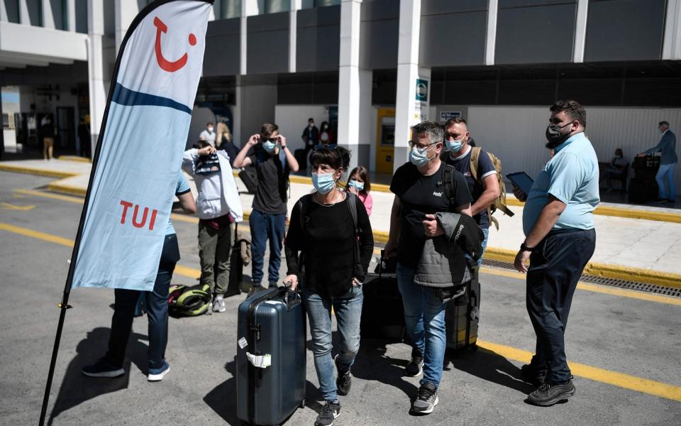 Tourists arrive to catch a bus as they leave - AFP