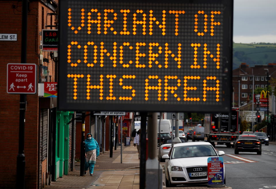 A woman walks past an information sign amid the outbreak of the coronavirus disease (COVID-19) in Bolton, Britain, May 17, 2021. REUTERS/Phil Noble