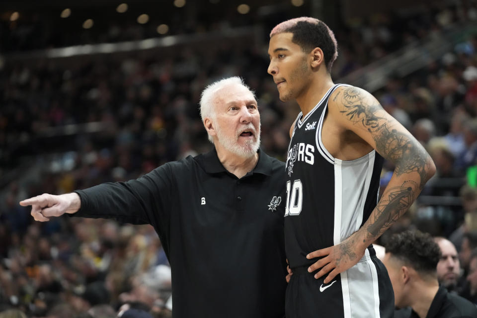 San Antonio Spurs head coach Gregg Popovich speaks with Jeremy Sochan (10) during the first half of an NBA basketball game against the Utah Jazz Tuesday, Feb. 28, 2023, in Salt Lake City. (AP Photo/Rick Bowmer)