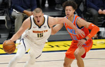 Denver Nuggets center Nikola Jokic, left, drives to the rim past Oklahoma City Thunder forward Isaiah Roby in the first half of an NBA basketball game Tuesday, Jan. 19, 2021, in Denver. (AP Photo/David Zalubowski)