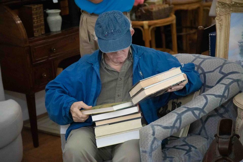 A man browses through a stack of books inside the Church Mouse on Monday during the resale store's first day of business for the 2023-24 season.