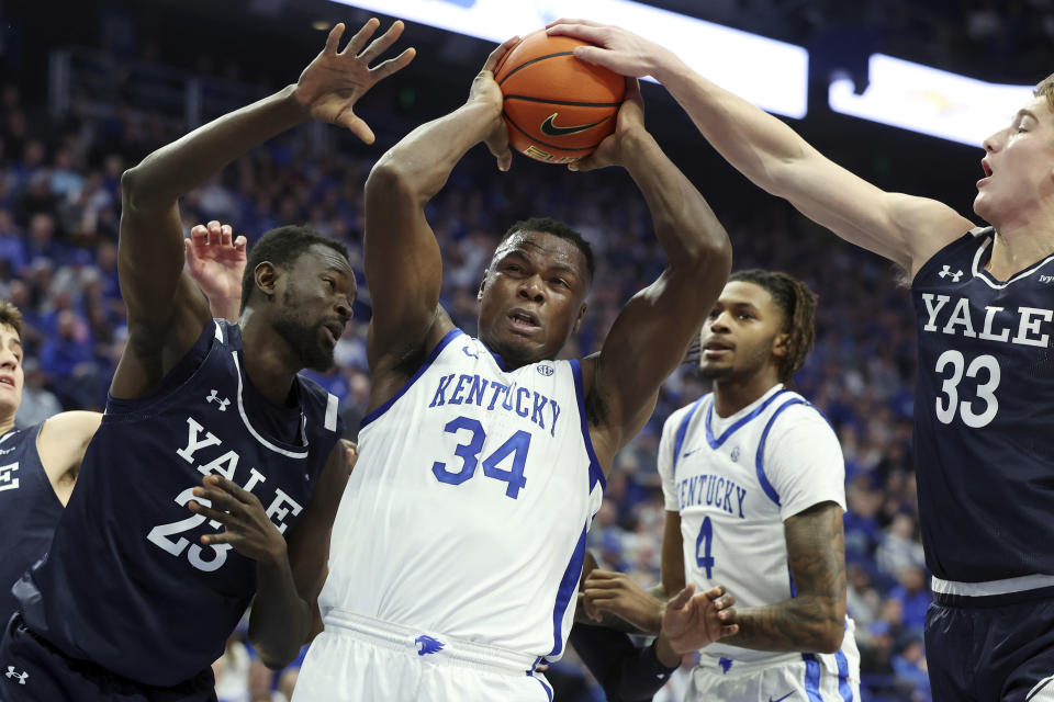 Kentucky's Oscar Tshiebwe (34) is pressured by Yale's Jack Molloy (33) and Yussif Basa-Ama (23) during the first half of an NCAA college basketball game in Lexington, Ky., Saturday, Dec. 10, 2022. (AP Photo/James Crisp)
